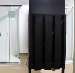 A bathroom with two glass shower enclosures and a black wooden divider at Ballybeg Pod 1 Ballybeg near Tinahely County Wicklow