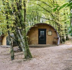 Two wooden pod cabins in a wooded area with trees and gravel ground at Ballybeg Pod 5 Ballybeg near Tinahely County Wicklow