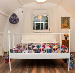 A bedroom with a white metal bed frame and a multicolored quilt on the bed at Ballybeg Pod 7 Ballybeg near Tinahely County Wicklow