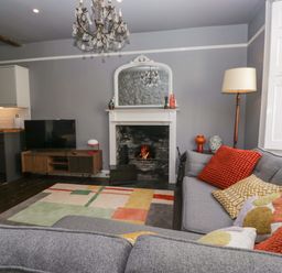 A living room with a sofa and television at Unicorn Cottage 
