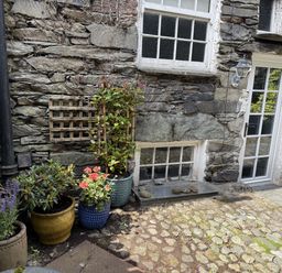 An outdoor area with plants and stone walls at Unicorn Cottage in Ambleside