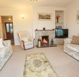 A living room with sofas armchair fireplace and television at Artists Cottage in Minffordd near Penrhyndeudraeth
