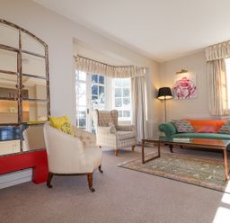 A living room with armchairs sofa coffee table and large window at Holm Oak Lodge in Tendring near Weeley