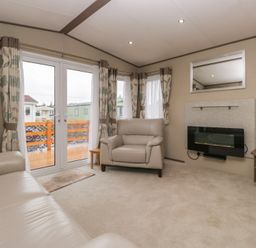 A living room with sofa and television at Aspen in Denny