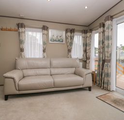 A living room with a sofa and curtains at Aspen in Denny