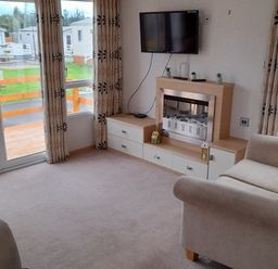 A living room with a television and sofa at Oak in Denny