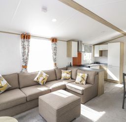 A living room with a kitchen and seating area at Ash in Denny