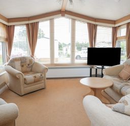 A living room with a sofa and television at Birch in Denny