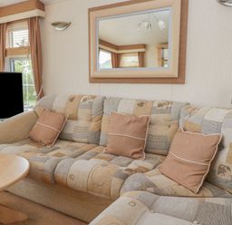 A living room with a sofa and television at Birch in Denny