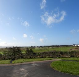 An outdoor view of a paved path and grassy fields with houses in the distance at 69 Ffordd Y Meillion in Llanelli