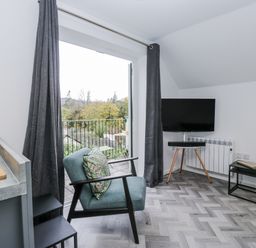 A living room with a television and sofa at Claife Flights in Bowness-On-Windermere