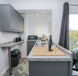 A kitchen with a sink and bar area at Claife Flights in Bowness-On-Windermere