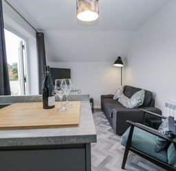 A living room with a sofa and wine glasses at Claife Flights in Bowness-On-Windermere