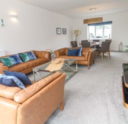 A living room with sofas and a dining area at Miramar in St. Ives