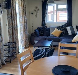 A living room with a sofa and coffee table at Gwanda in Tregolds near St Merryn