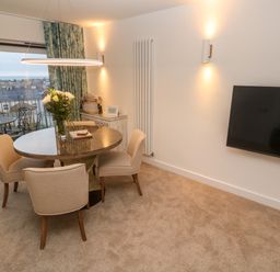 A dining area with round table and four chairs near a balcony door with outdoor seating at Fal View in Falmouth