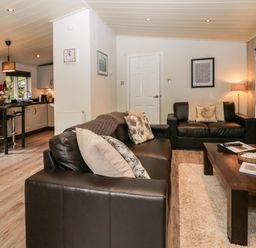 A living room with brown sofas and a wooden coffee table at Somerford Lodge Langdale 7 White Cross Bay near Windermere