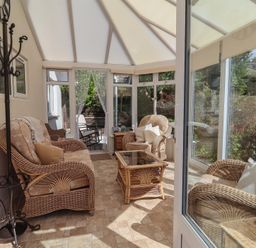 A conservatory with wicker furniture at Little Willesleigh Goodleigh near Barnstaple