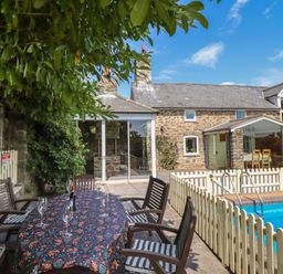 An outdoor area with a table and chairs near a swimming pool at Bryn Y Garreg Cottage - The Wireless Free Farm in Llangadfan near Llanwddyn