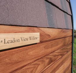 A wooden sign reading Leadon View Willow on a wooden exterior wall with a grassy field in the background at Leadon View Willow in Upleadon near Newent