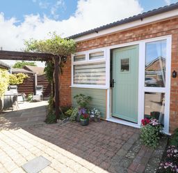 An entrance area with a door and potted plants at Rainbow's End in Swanton Morley