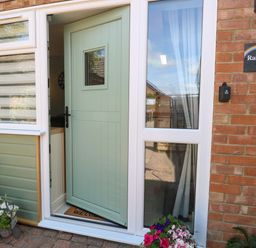 An entrance with a green door and plant decorations at Rainbow's End in Swanton Morley