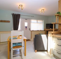 A kitchen with a dining table and a refrigerator at Rainbow's End in Swanton Morley
