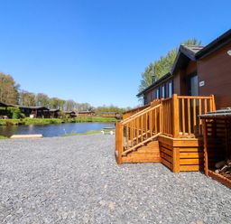 An outdoor area with wooden stairs and a lake at Lakeside Lodge in Bowland Lakes Leisure Village near Garstang