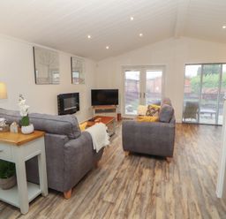 A living room with sofas and a television at Dovedale Lodge in Bowness 70, White Cross Bay near Windermere