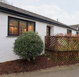 An exterior view of a building with a plant and fence at Jasmine Cottage in Thornthwaite