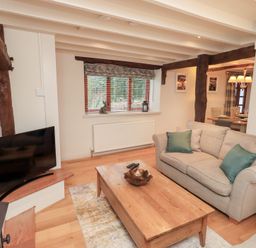 A living room with a sofa and coffee table at Jasmine Cottage Thornthwaite