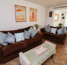 A living room with two brown sofas and a coffee table with a tray at Coastal Retreat in Seahouses