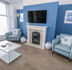 A living room with a television and fireplace at Vista Mare 1 Weymouth