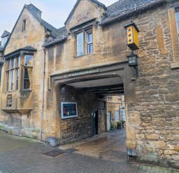 Old stone building with an archway entrance and windows on a paved street at 4 Noel Court in Chipping Campden