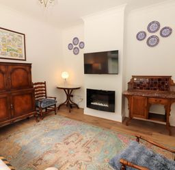 A living room with a television and a chair at Rosemont in Adare