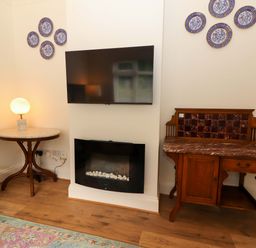 A living room with a television and decorative plates at Rosemont in Adare