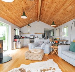A living room with a sofa and a fireplace at Smugglers Bodmin Moor, St Breward near St Tudy