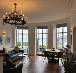 A living room with large windows and a dining area at Bayview Tower in Lynton