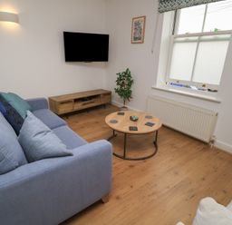 A living room with a sofa and television at Weyside in Weymouth