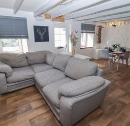 A living room with a sofa and dining area at 41 St. James Street Narberth