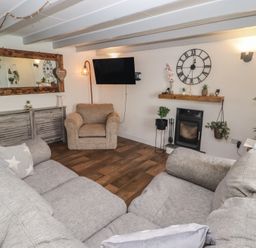 A living room with a sofa and an armchair at 41 St. James Street Narberth
