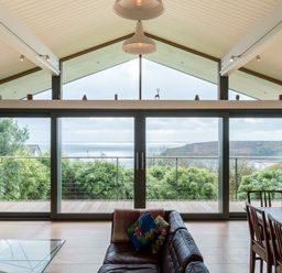 A living room with a sofa and dining table at Green Shutters near Freshwater East