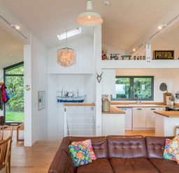 An open living area with a kitchen and dining table at Green Shutters in Freshwater East near Lamphey