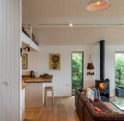 A living room with a coffee table and windows at Green Shutters in Freshwater East near Lamphey