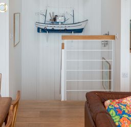 A living room with a model boat on the wall at Green Shutters near Freshwater East