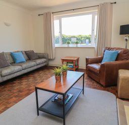 A living room with a coffee table and seating at Bayview Cottage in Southbourne