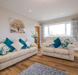 A living room with two sofas and patterned cushions at Little Hillside in Redruth