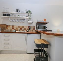 A kitchen with a sink and microwave at Oakley View Apartment in Porthmadog