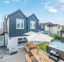 Outdoor seating area with a jacuzzi and garden shed at Palm House in Newquay