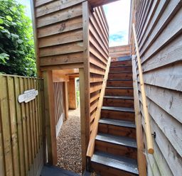 An outdoor area with stairs and a welcome sign at The Halt in Maiden Newton